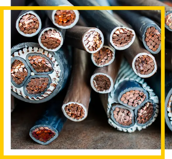 Close-up view of several thick electrical cables with exposed copper wire ends, arranged in a group on a flat surface, showing the internal structure and wire bundles. A yellow and white border frames the image.